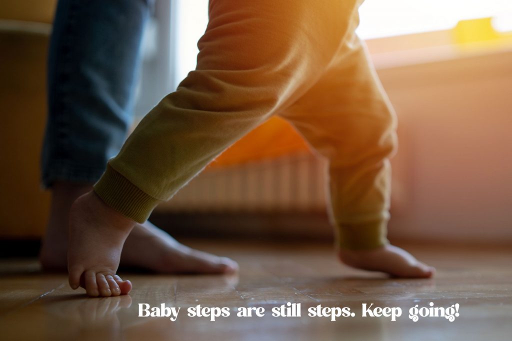 picture shows a baby's feet and legs walking wtih help of a parent. Text at bottom reads "Baby steps are still steps. Keep going!"