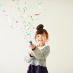 a little girl is celebrating with confetti