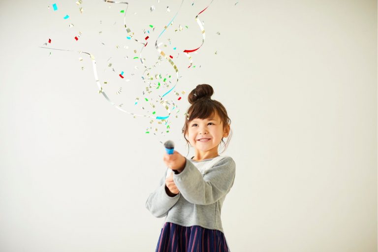 a little girl is celebrating with confetti