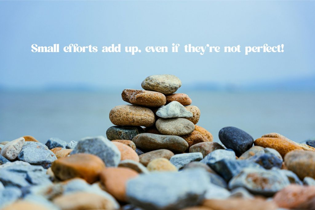 Image show a pile of rocks stacked in front of water into a mini mountain with text above that says "Small efforts add up, even if they’re not perfect!"