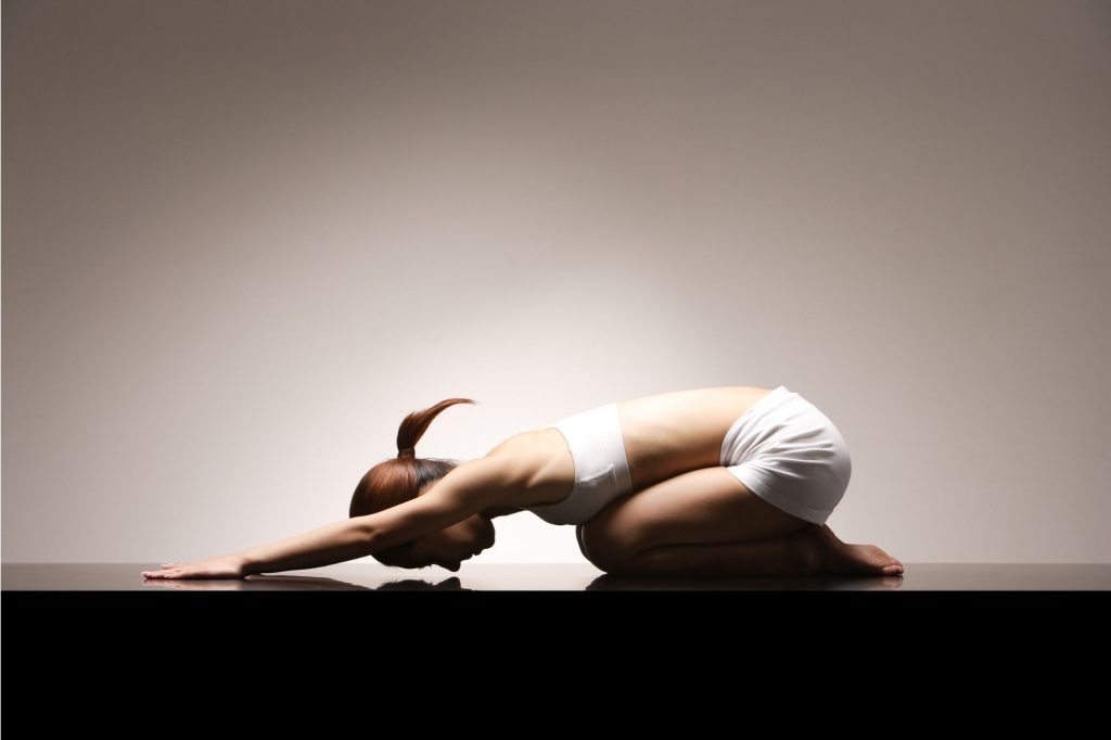 a woman is in child's pose 