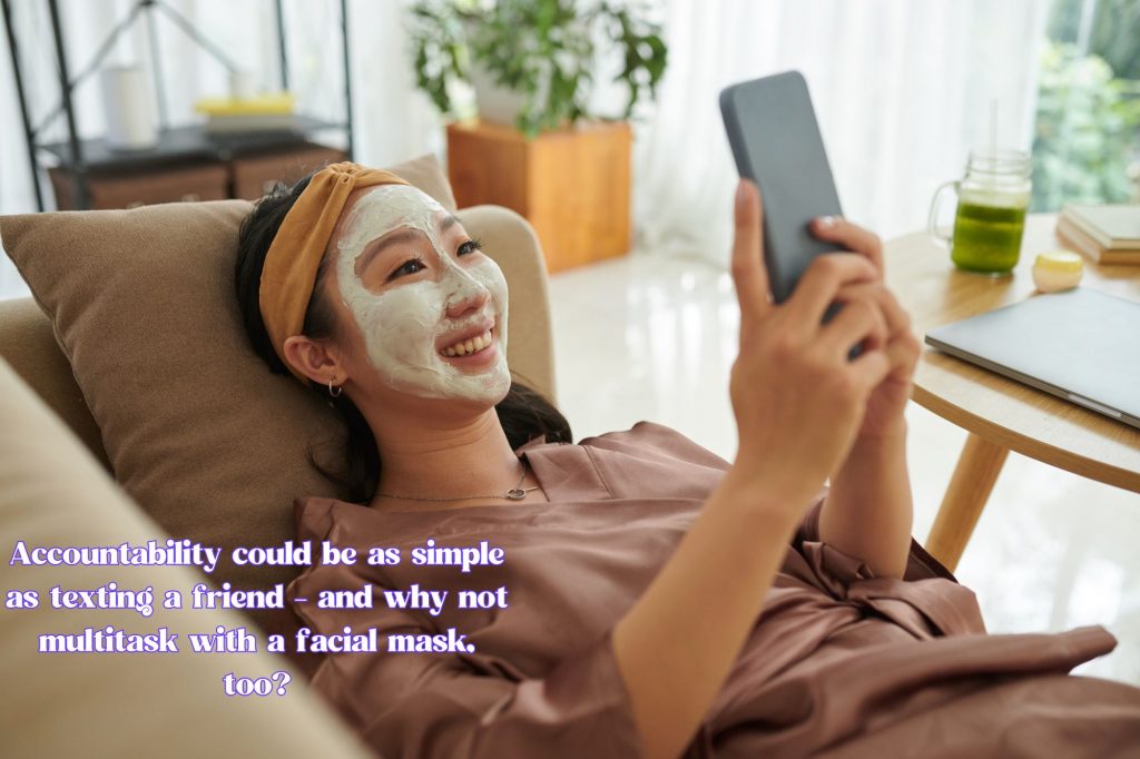 woman is on her phone with facial mask on with text overlay that reads "accountability could be as simple as texting a friend - and why not multitask with a facial mask, too?"