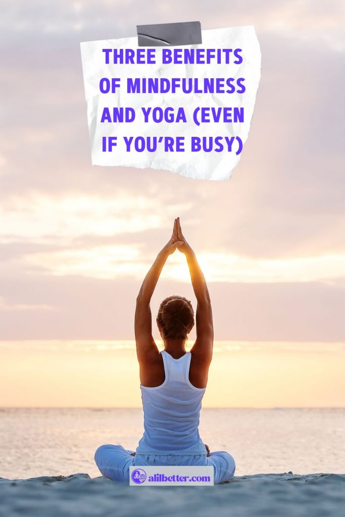 A woman is sitting on the beach with her palms together above her head and text overlay that reads "three benefits of mindfulness and yoga"